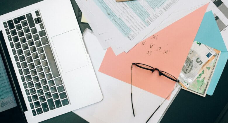 Ordinateur, lunettes et papiers sur un bureau