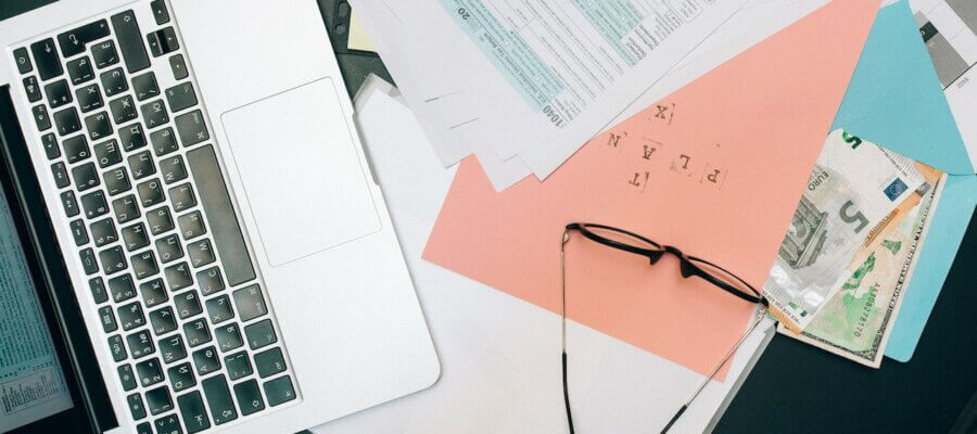 Ordinateur, lunettes et papiers sur un bureau